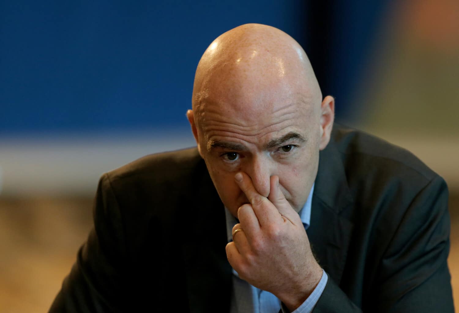 Gianni Infantino ubrany w czarną marynarkę podczas konferencji prasowej.