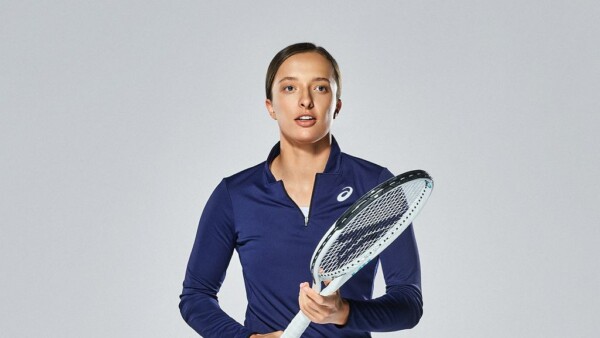 Iga Świątek w ciemnoniebieskim stroju z rakietą tenisową w dłoni.