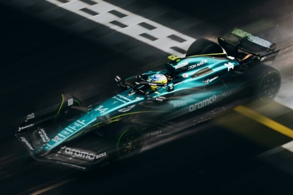 Bolid Aston Martin F1 z numerem 14 na torze podczas wyścigu Formuły 1, widoczny branding Aramco i dynamiczny ruch.