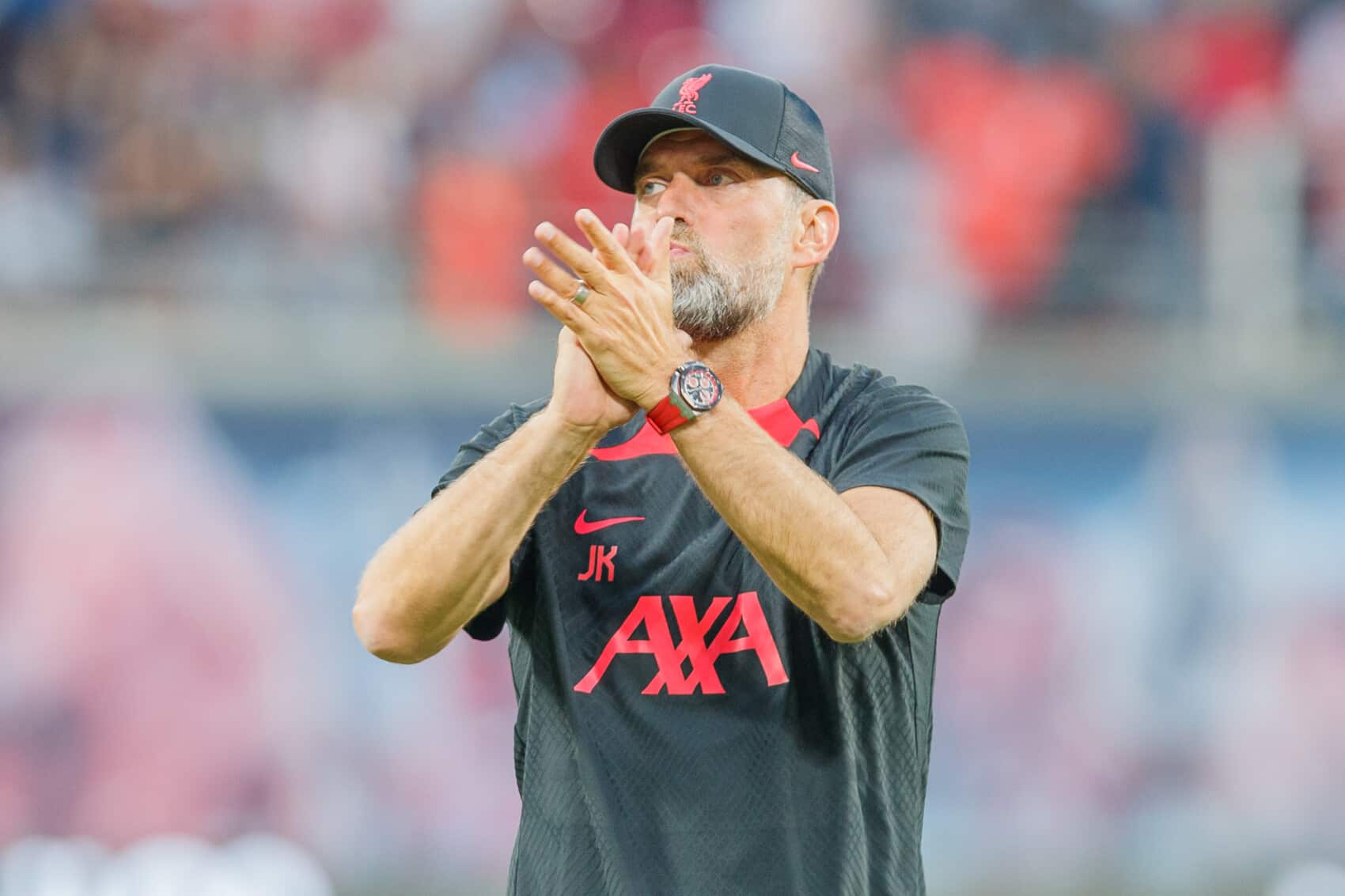Jurgen Klopp w stroju Liverpool FC bije brawo na stadionie podczas meczu piłkarskiego
