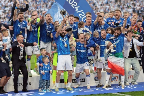 Piłkarze Lecha Poznań świętują zdobycie mistrzostwa Polski z trofeum na stadionie