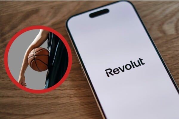 Mężczyzna trzymający piłkę do koszykówki oraz telefon z napisem Revolut na ekranie