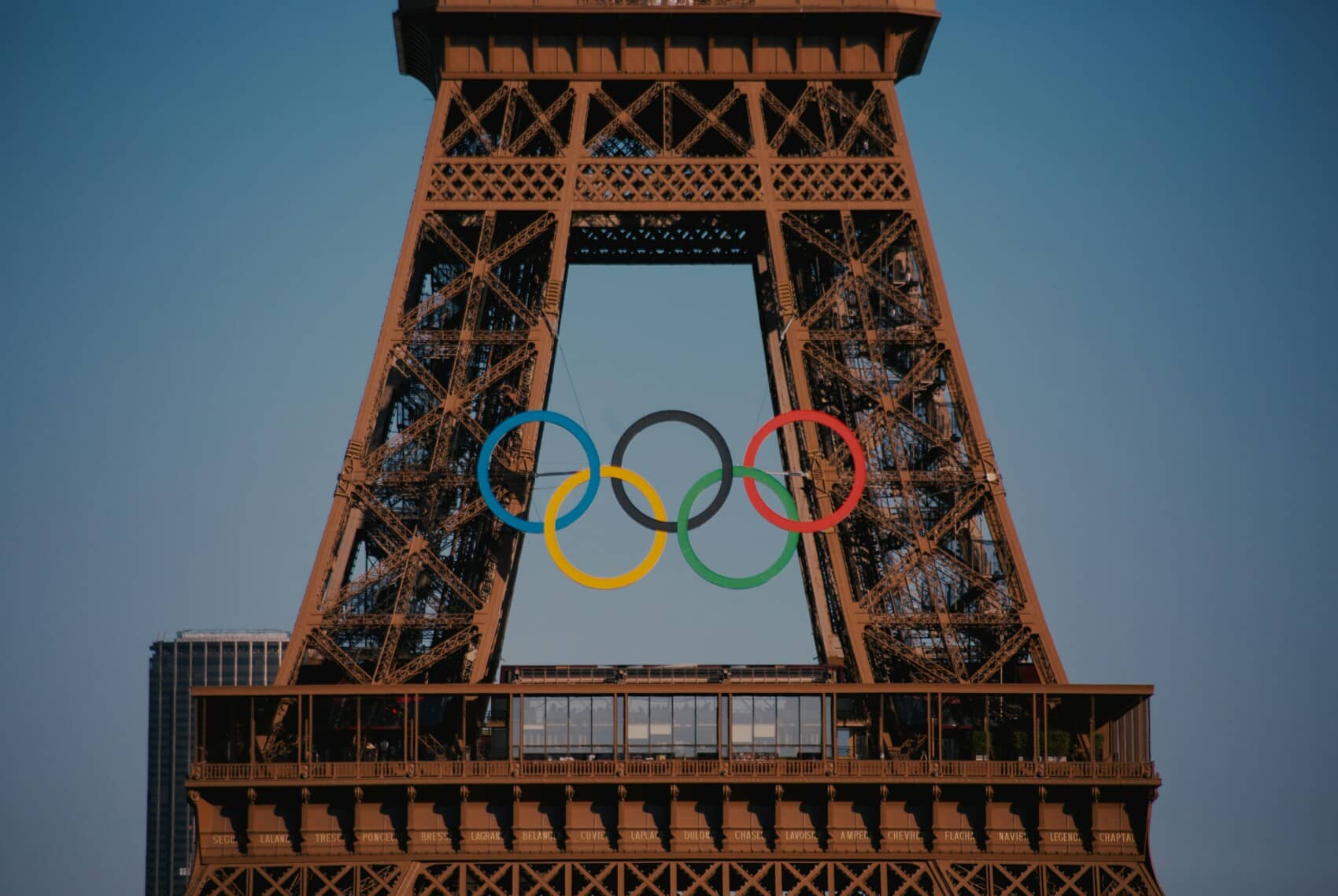 Widok na wieżę Eiffla z zawieszonymi olimpijskimi pierścieniami przed igrzyskami olimpijskimi w Paryżu 2024