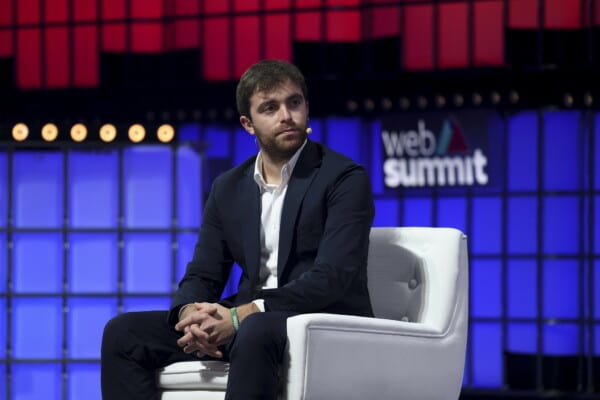 Fabrizio Romano w garniturze na scenie Web Summit 2025, z mikrofonem, na tle logo wydarzenia, bierze udział w panelu sportowym
