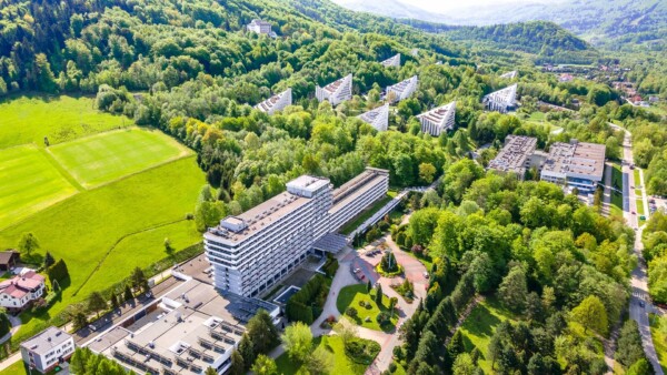 Kompleks sanatoryjny Uzdrowiska Ustroń w otoczeniu gór i lasów, widok z lotu ptaka w pogodny dzień.
