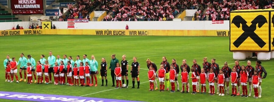 Drużyny Austrii i Islandii wraz z dziećmi podczas prezentacji przed meczem eliminacji UEFA Women’s Euro 2025 na Stadionie Austria Wien, kibice z flagami w tle