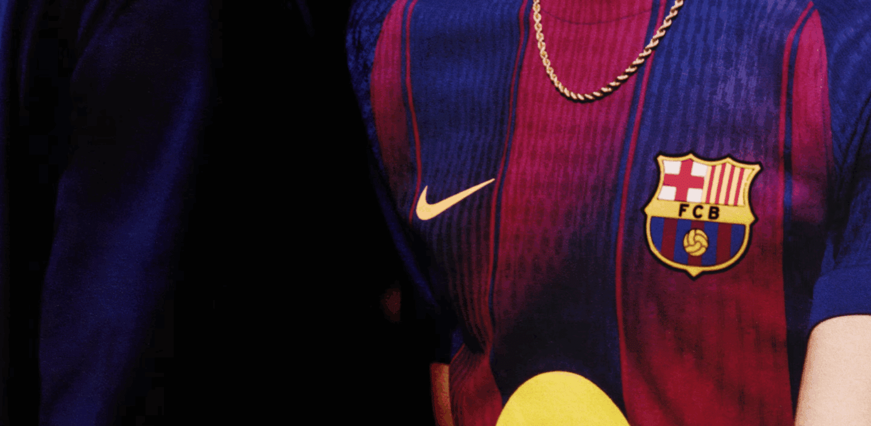 Fragment koszulki piłkarskiej FC Barcelona z wyraźnym herbem klubu i logo Nike, przedstawiony z bliska.