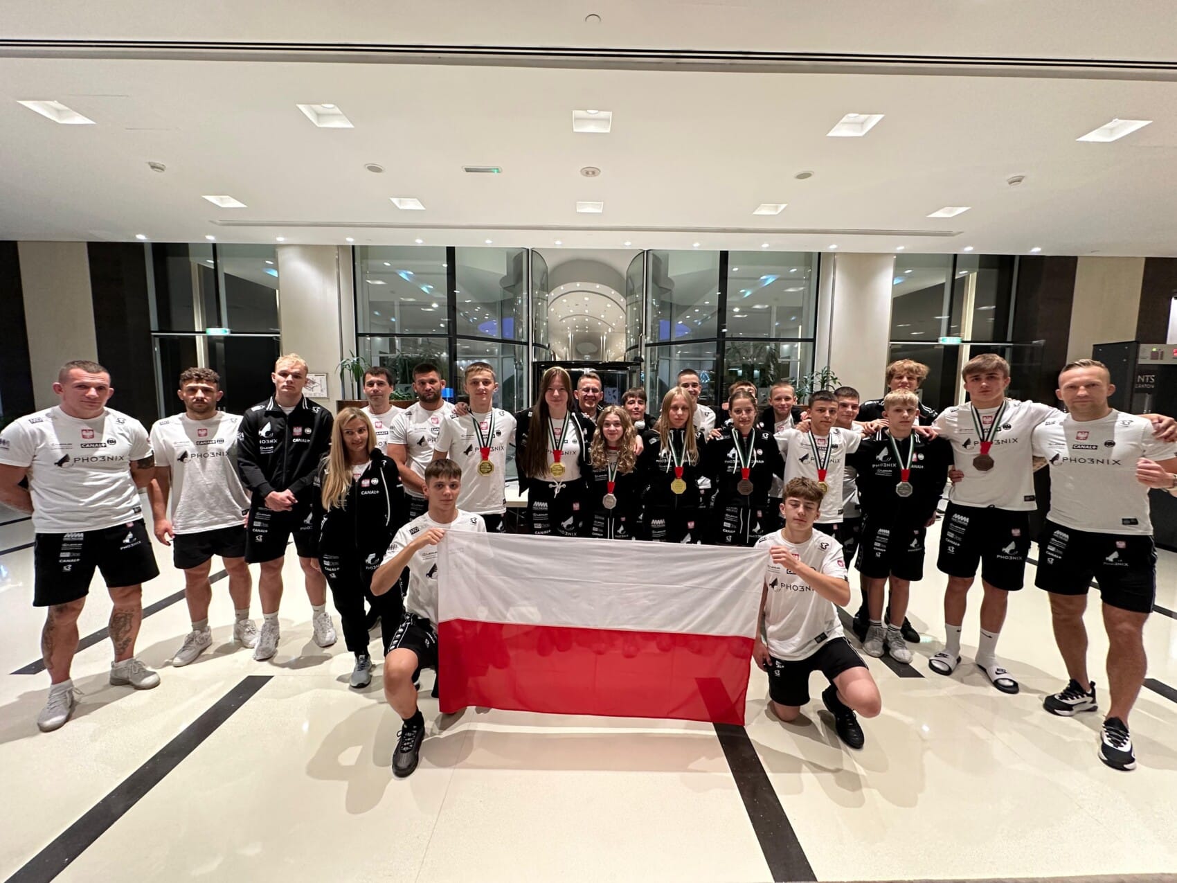 Reprezentacja Polski w MMA młodzieży z medalami i flagą Polski podczas Mistrzostw Świata IMMAF 2025 w Zjednoczonych Emiratach Arabskich