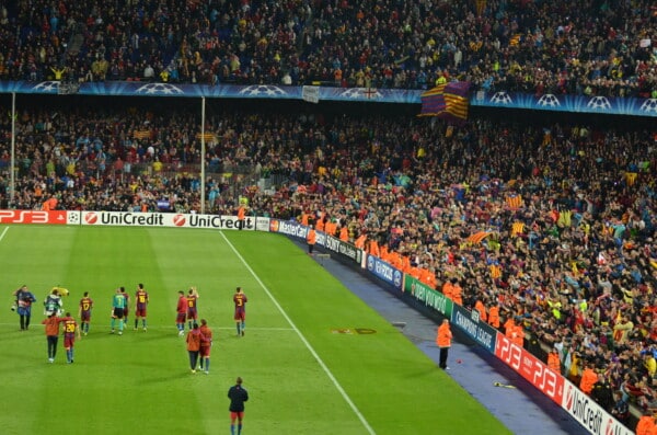 Zdjęcie z meczu FC Barcelony na Camp Nou podczas Ligi Mistrzów – piłkarze na murawie, tłum kibiców w barwach Blaugrana, atmosfera stadionu w Barcelonie