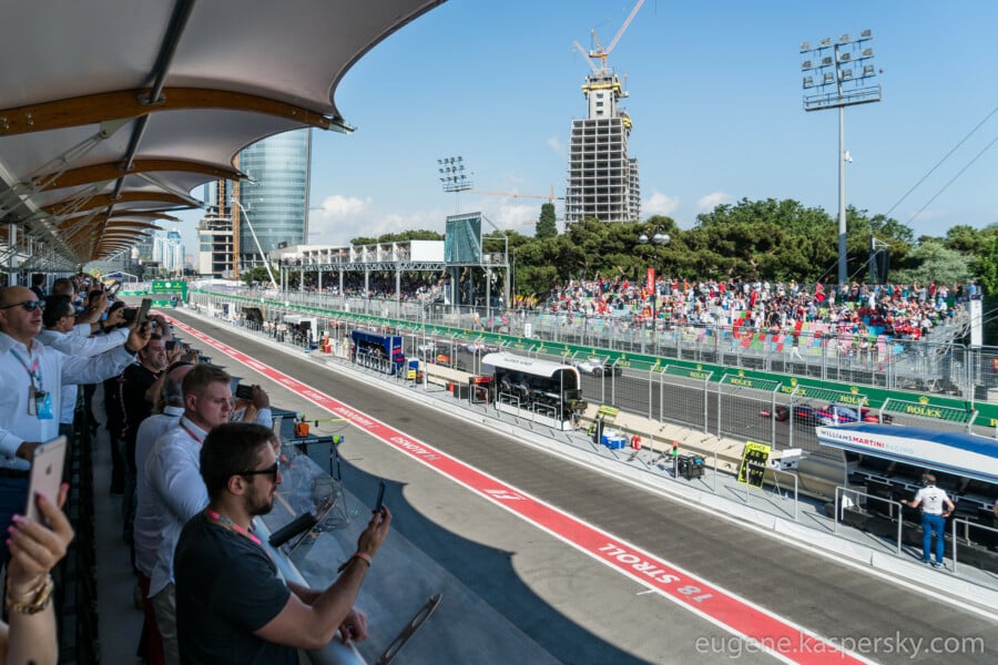 Widok na trybuny i pit lane podczas Grand Prix Formuły 1 w Baku na torze Baku City Circuit, kibice fotografują samochody na trasie.