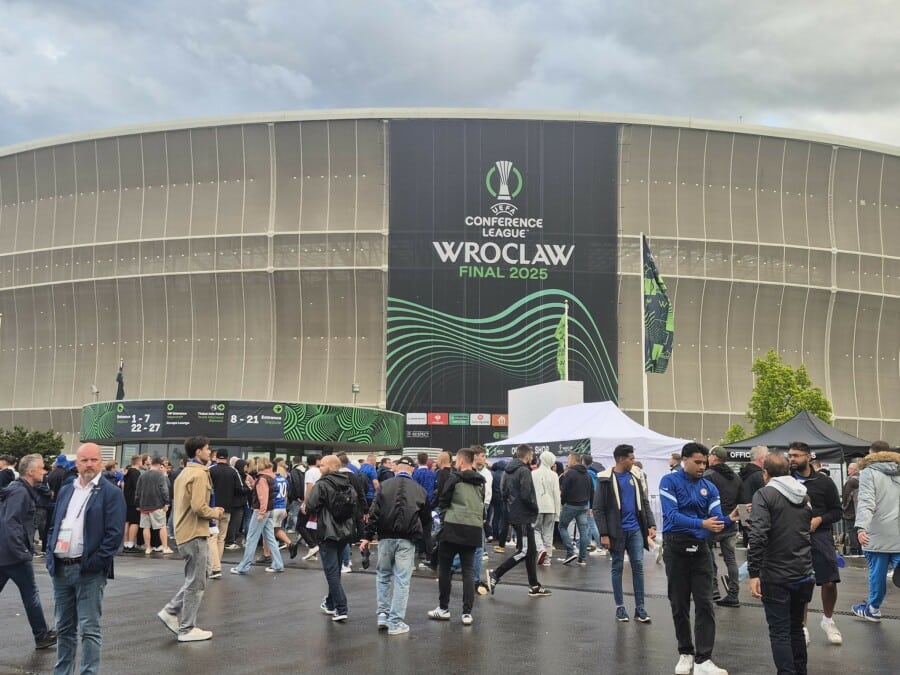 Tłum kibiców przed stadionem we Wrocławiu podczas finału UEFA Conference League 2025, duży baner z logo i napisem „Wrocław Final 2025” na fasadzie stadionu.