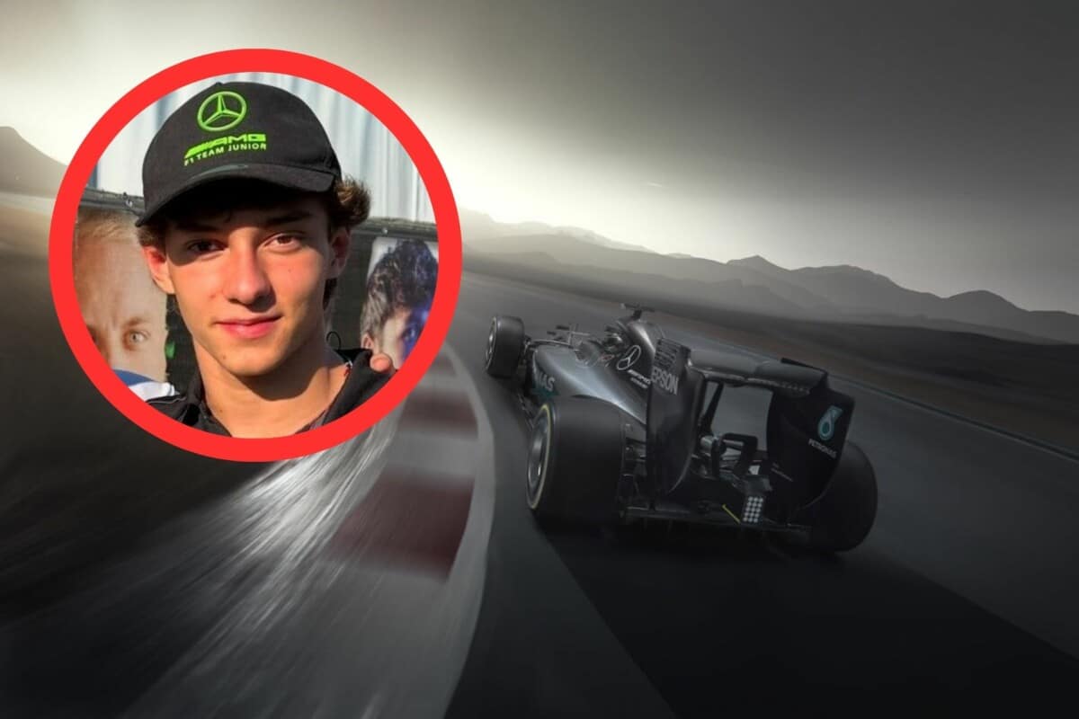 Członek Mercedes AMG Petronas Junior Team w czapce zespołu, stojący przed plakatem, z bolidem Formuły 1 jadącym po torze w tle
