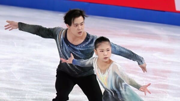 Para łyżwiarzy figurowych Jiaxuan Zhang i Yihang Huang wykonują program podczas jazdy na lodzie na zawodach Junior Grand Prix Final sezonu 2024/25.