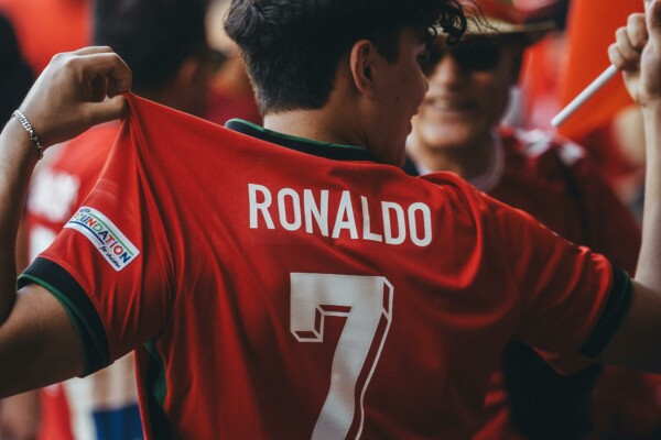 Kibic pokazuje koszulkę piłkarską Cristiano Ronaldo z numerem 7 podczas wydarzenia sportowego.
