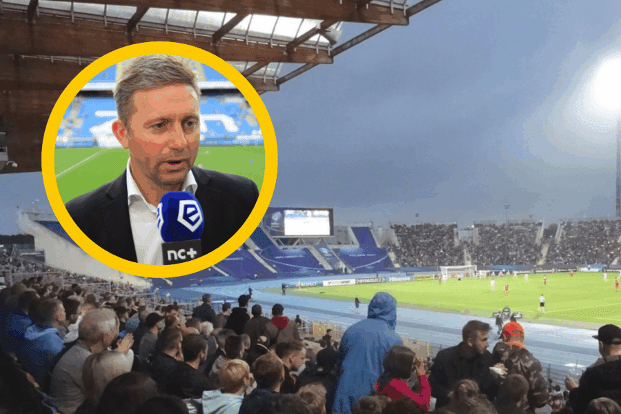 Jerzy Brzęczek, selekcjoner reprezentacji Polski U-21, udziela wywiadu na tle stadionu pełnego kibiców podczas meczu piłkarskiego Ekstraklasy.​