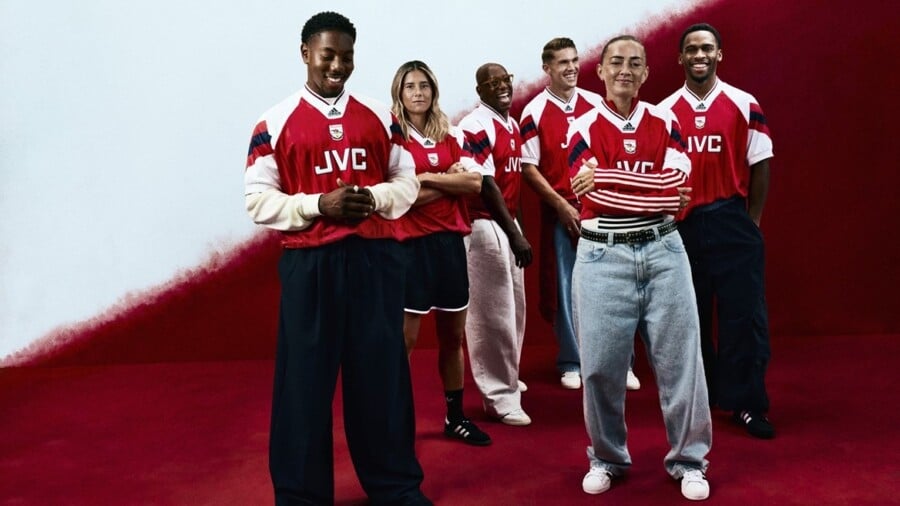 Grupa młodych osób w retro koszulkach piłkarskich Arsenal z logo JVC na czerwonym tle, prezentujących klasyczne stroje piłkarskie Adidas.