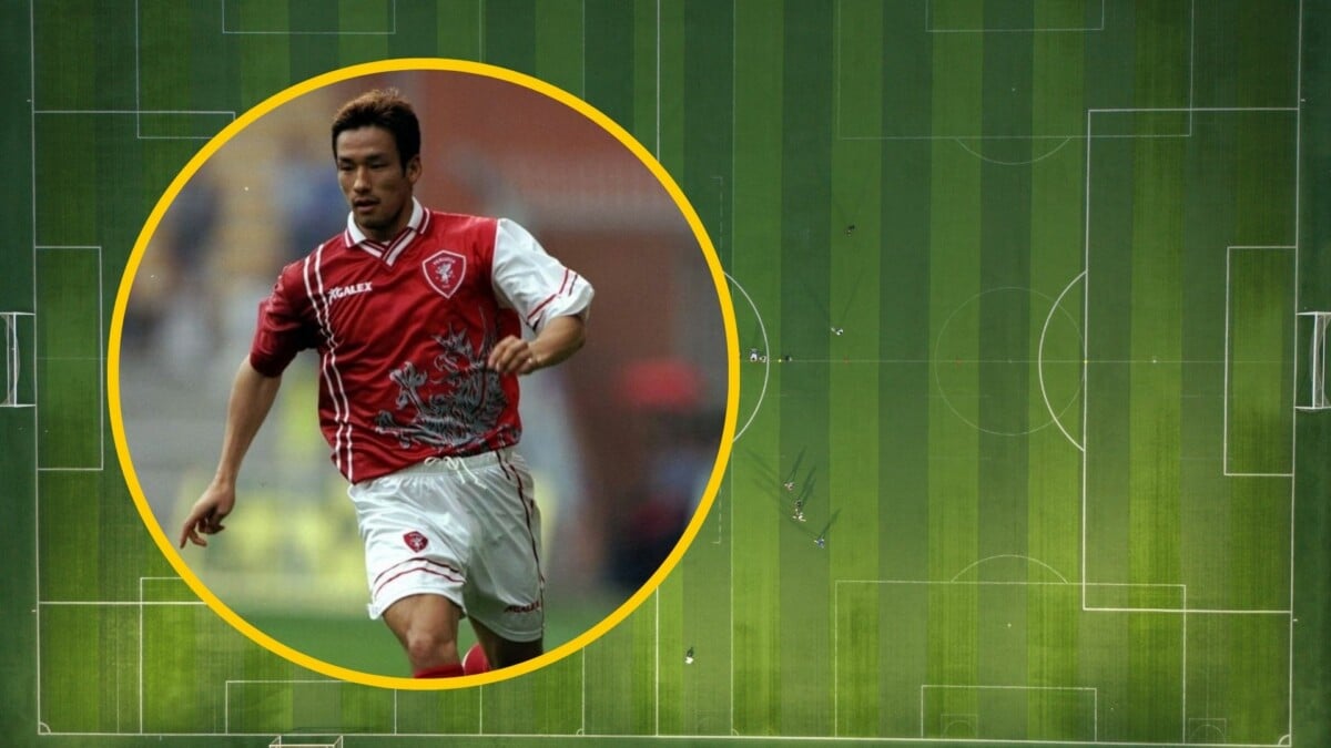 Piłkarz w czerwonej koszulce w żółtym okręgu na tle zielonego boiska piłkarskiego widzianego z lotu ptaka