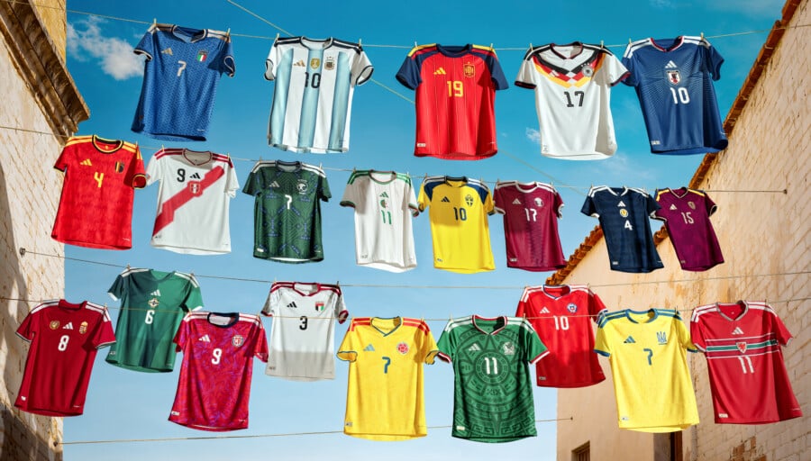 Nowa kolekcja domowych koszulek adidas na Mundial 2026, prezentująca stroje 22 reprezentacji narodowych, zawieszone na sznurku na tle nieba.