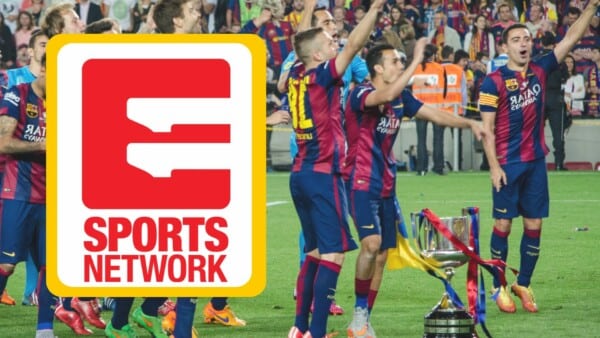 Piłkarze FC Barcelony w bordowo‑granatowych strojach świętują zdobycie pucharu na boisku, otoczeni kibicami na trybunach, obok dużego logo stacji telewizyjnej Sports Network.