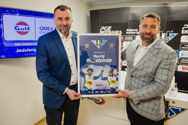 Dwaj mężczyźni w garniturach prezentują umowę sponsoringu między GULF a FOGO Unią Leszno na sezonie 2026, w tle ekran z logotypami GULF i QMEX ENERGY