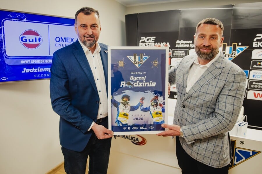 Dwaj mężczyźni w garniturach prezentują umowę sponsoringu między GULF a FOGO Unią Leszno na sezonie 2026, w tle ekran z logotypami GULF i QMEX ENERGY