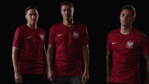 Zdjęcie reprezentantów kadry Polski w piłce nożnej. Prezentują nową koszulę - w czerwonym kolorze. Od lewej: Piotr Zieliński, Robert Lewandowski, Nicola Zalewski.