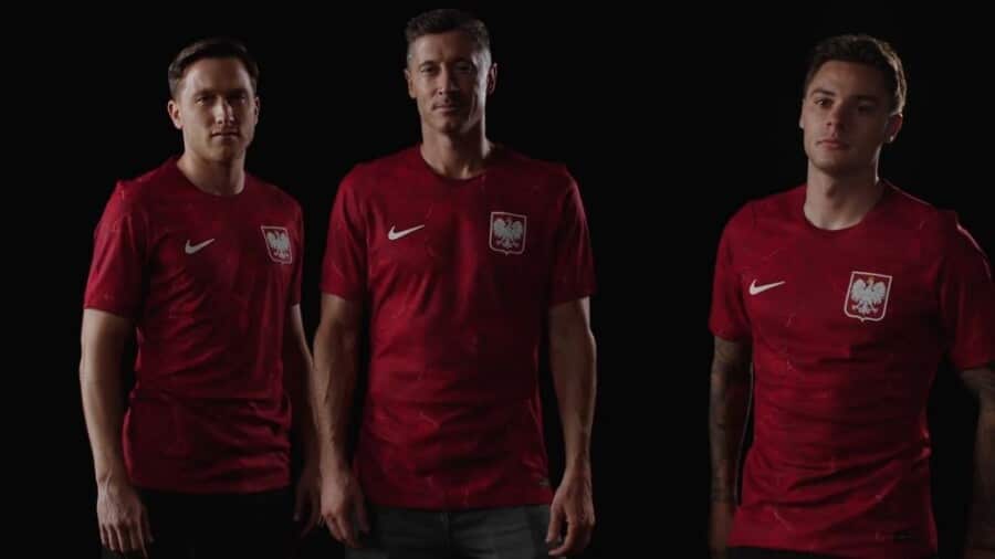 Zdjęcie reprezentantów kadry Polski w piłce nożnej. Prezentują nową koszulę - w czerwonym kolorze. Od lewej: Piotr Zieliński, Robert Lewandowski, Nicola Zalewski.
