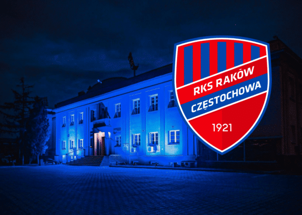 Raków Częstochowa Celebruje Światowy Dzień Świadomości Autyzmu przy L83 – na zdjęciu widać budynek klubowy podświetlony na niebiesko, a także herb Rakowa Częstochowa.