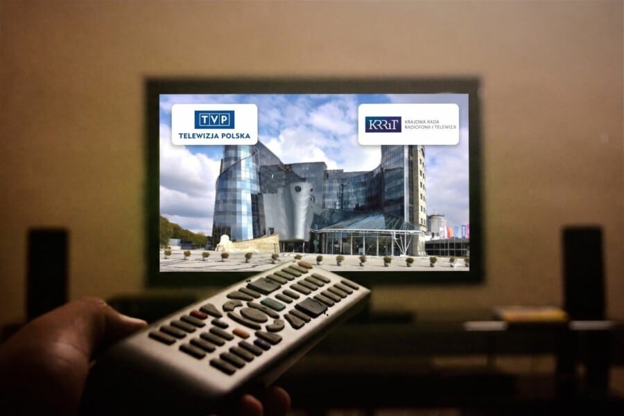 Widok na ekran telewizora pokazujący budynek siedziby Telewizji Polskiej z nałożonymi logotypami TVP oraz KRRiT, nawiązujący do sporu o brak transmisji Mundialu 2026 w jakości 4K.